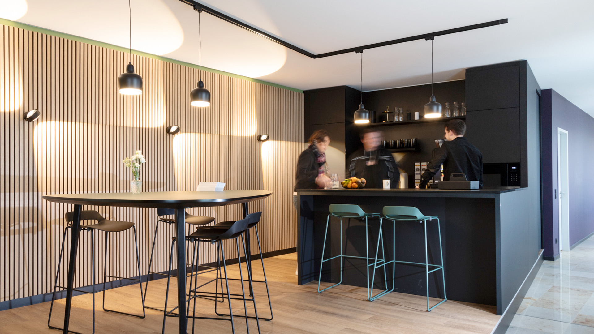Eine moderne Küche mit Bar und Hockern, Referenzprojekt von projekt k in Münster, Lounge bei der RATIO Unternehmensgruppe.