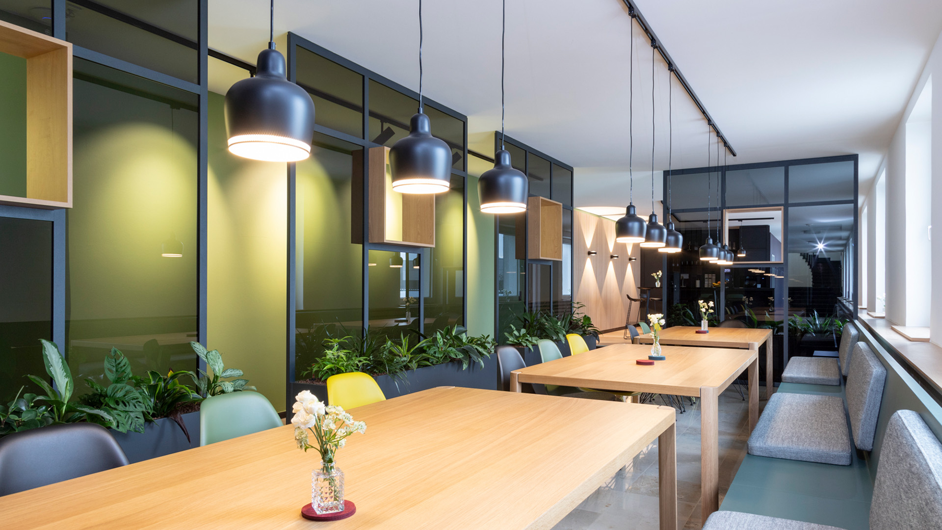 Restaurant mit Glastrennwänden, Tischen und Stühlen, Referenzprojekt von projekt k in Münster, Lounge-Einrichtung bei RATIO Unternehmensgruppe.